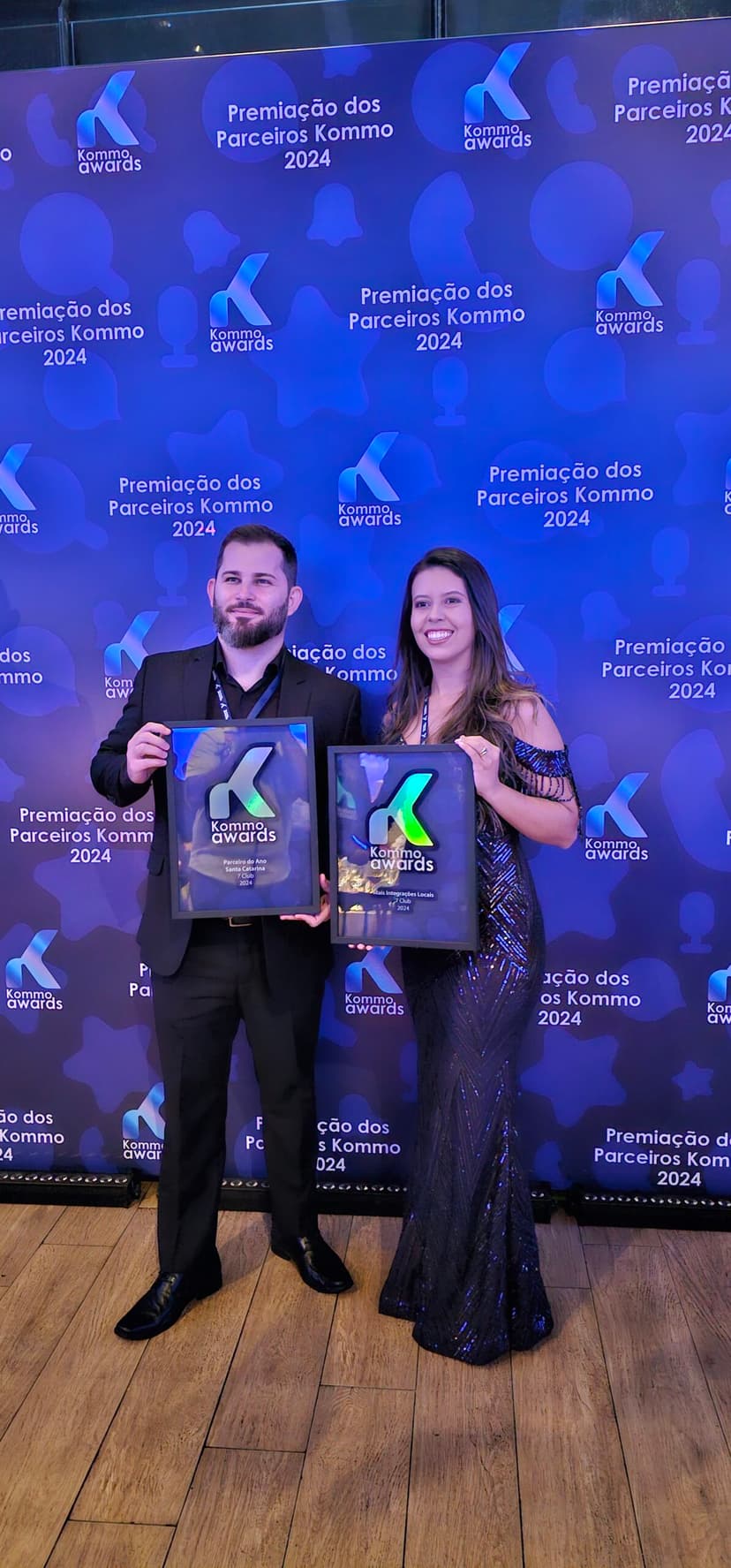 Equipe 7Club premiada como parceira oficial Kommo, segurando os troféus